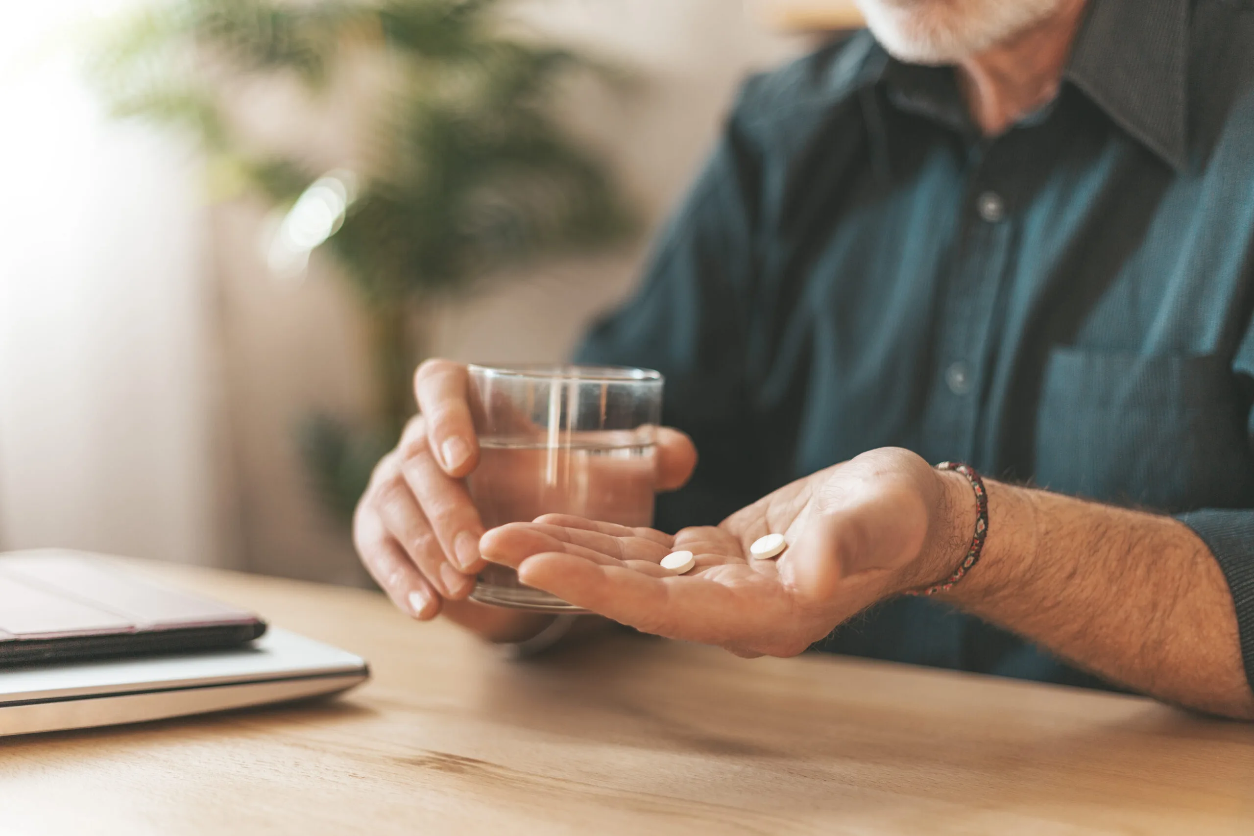 Taking medications at home. Daily dose of vitamins for the elderly in hand, headache tablets. Sedation pills.