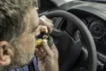 Stock photo of a man smoking marijuana in a vehicle driving a car under the influence of cannabis.